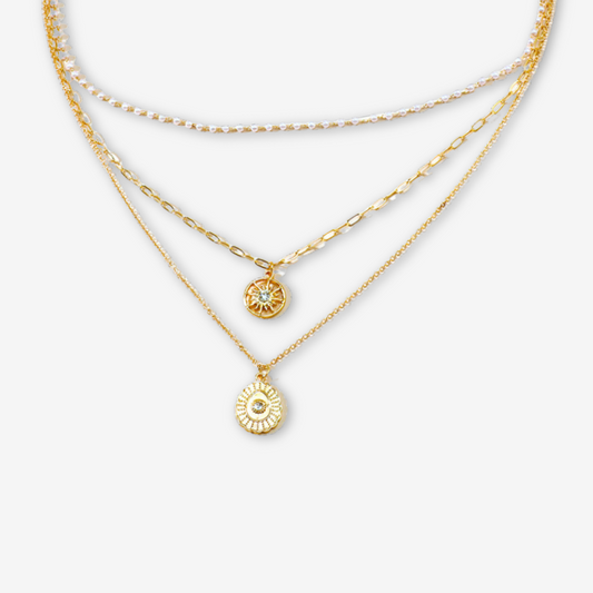 Collana triplo strato con piccole perle e medaglione solare.